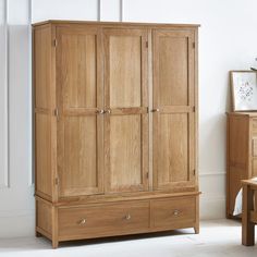 a wooden armoire in a room with white walls