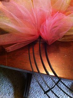 a close up of a piece of cloth on top of a wooden table with wire