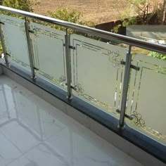 a balcony with glass railings and white tile flooring on the side of it