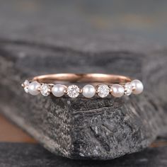 a close up of a ring with pearls on it sitting on a piece of rock