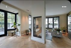 a living room filled with lots of windows next to a wooden floor covered in furniture