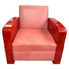 a pink leather chair sitting on top of a white floor next to a wooden frame