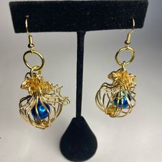 Festive Handmade Gold Caged Blue Bell Dangle Earrings Gold Filled Wire With A Handmade Wrapped Wire Design Encasing A Single Blue Bell. The Ear Wire Is Also Gold Filled. 3” Length Bell Earrings, Wire Jewelery, Dangle Earrings Gold, Wire Design, Holiday Earrings, Blue Bell, Holiday Earring, The Ear, Handmade Wire