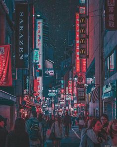 a crowded city street at night with neon signs