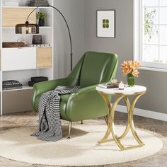 a green chair sitting on top of a white rug next to a table with flowers