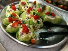 a silver plate topped with lettuce and tomatoes