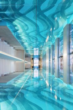 an empty room with blue and white designs on the walls, reflecting light onto the floor