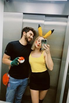 a man and woman taking a selfie in an elevator with pikachu ears