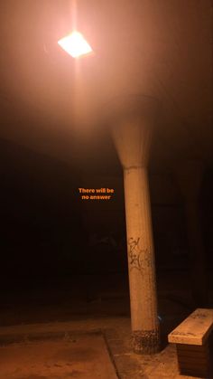 a light that is on top of a pillar in the dark night sky with words written below it