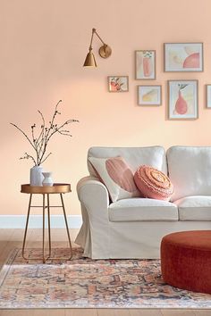 a living room filled with furniture and pictures on the wall next to a coffee table