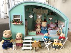 a group of stuffed animals sitting in front of a doll house