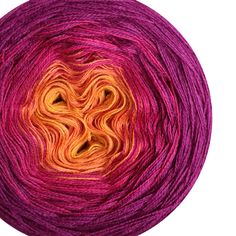 a ball of yarn that has been dyed in purple and orange colors with an orange center