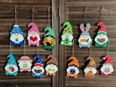 cross stitch christmas ornaments hanging on a wooden wall