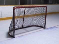 an ice hockey goal sitting on top of a rink