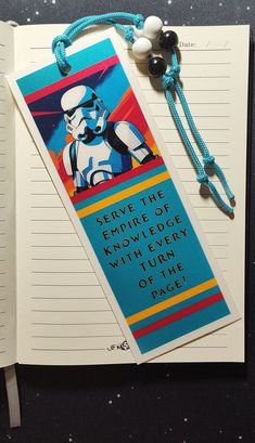 an open notebook with a star wars bookmark on it and a string attached to the cover