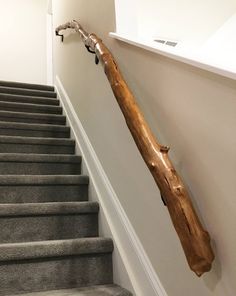 a wooden stick is hanging on the wall next to some stairs