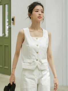 This is a refined and minimal vest by Siyazu that is made out of high quality and sturdy material. With classic mood of the design and feminine look, you can style it for your refined and casual daily outfit.- Set up with matching pants- Bio processed fabric with soft touch- Curved square neckline- Ox horn buttons detail Elegant Everyday Cotton Tank Top, White Linen Vest For Workwear, Elegant Spring Vest, Elegant Solid Color Vest For Summer, Elegant Vest For Spring, Elegant Solid Vest For Spring, Chic Linen Vest For Day Out, Beige Cotton Tank Top For Work, Chic White Vest With Pockets