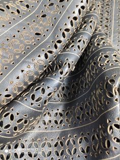 close up view of an intricate design on a black leather material with gold foiling