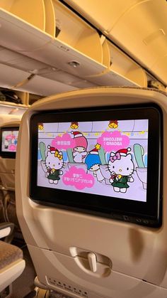 an airplane with hello kitty on it's screen and seats in the back ground