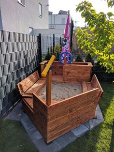 a wooden sandbox in the middle of a yard