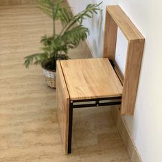 a wooden bench sitting next to a plant