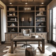 an office with built in bookcases and leather chairs, along with a desk