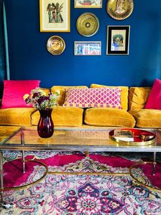 a living room filled with furniture and pictures on the wall above it's coffee table