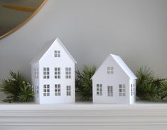 two white houses sitting on top of a mantle