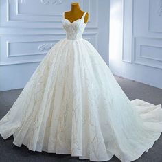 a wedding dress on display in a white room