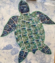 a turtle made out of stamps sitting on top of a table