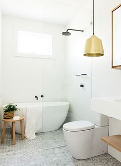 a bathroom with a toilet, sink and bathtub next to a wooden step stool