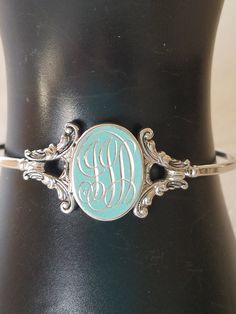 "Featuring this 1980's silver tone Signed Avon bangle or cuff. It has two ornate bezel clasp and an oval locket for a photo. On the hinged front door are the initials \"JJD or JJA\" in an elegant font. This bangle has never been worn and is in near mint condition. Locket has a secure lock. I purchased a lot of Avon Jewelry from an Estate Sale in Thornton, and this was in it. It would make an excellent Christmas gift or Birthday Gift. It will arrive carefully packaged with FREE SHIPPING. Measures Oval Locket, Avon Jewelry, Elegant Font, Shiny Silver, Base Metal, Estate Sale, Brighton, Locket, Mint Condition