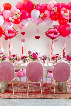 the table is set with pink chairs and balloons