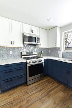 an empty kitchen with blue cabinets and white counter tops is pictured in this image from the front view