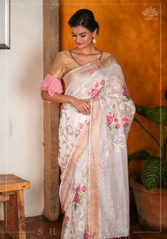 Elegance, woven in Ivory Silk Linen! Presenting this gorgeous silk Linen saree in White hues adorned with a golden zari border. The intricate floral embroidery in pretty shades adds to the regal charm of the saree. This trendy fabric is gossamer and has a subtle sheen on a lightly textured and crisp base. The embroidery is done  This saree is ready to wear with fall and pico done. Handmade silk tassels adorn the pallu and add more grace to it. An unstitched blouse fabric is included.*Note: There may be minor variations in the shade, the texture of the product. Hues/textures show differently due to variations in screen settings and other factors, *Note: This is a handwoven saree and there may be slight inconsistencies such as in it's weaving. These are characteristic of handmade products an Floral Embroidered Slub Silk Saree, Festival Pre-draped Saree In Tissue Silk With Floral Embroidery, Festival Tissue Silk Pre-draped Saree With Floral Embroidery, Festive Raw Silk Pre-draped Saree With Floral Embroidery, White Silk Traditional Wear With Floral Embroidery, Slub Silk Fabric With Floral Embroidery For Wedding, Wedding Slub Silk Fabric With Floral Embroidery, White Floral Embroidered Pre-draped Saree For Wedding, White Floral Embroidered Chanderi Pre-draped Saree