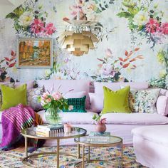 a living room filled with lots of furniture and flowers on the wall behind it's couch