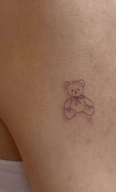 a small tattoo of a teddy bear on the back of a woman's thigh