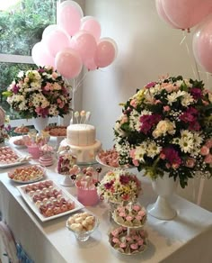 a table filled with lots of desserts and balloons on top of it's sides