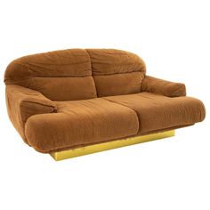 a brown couch sitting on top of a yellow stand up chair in front of a white wall