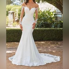 a woman in a white wedding dress posing for the camera with her hands on her hips