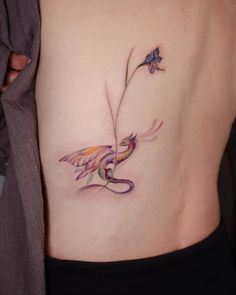 a woman with a tattoo on her stomach holding a flower in one hand and a butterfly in the other