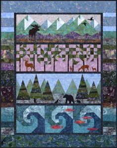 a quilted wall hanging with animals and mountains in the background, along with water