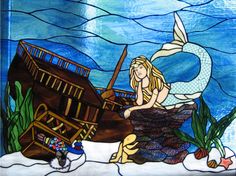 a stained glass window with a mermaid sitting on top of a boat in the water