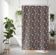 a bathroom with a shower curtain and potted plants on the floor next to it