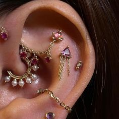 an ear with several different types of piercings attached to the side of its ear