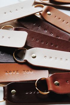 leather key fobs with personalized names on them are laid out in rows