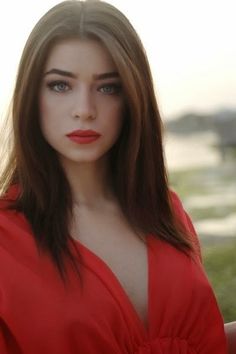 a woman in a red dress posing for the camera