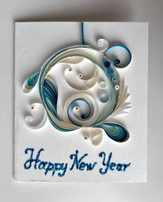 a happy new year card with blue and white swirls on the front, hanging from a string