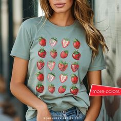 Stay stylish with our relaxed fit cotton t-shirt, featuring a trendy strawberry grid pattern. Perfect for a strawberry festival outfit or casual summer days. This graphic tee offers comfort and vibrant prints, making it a must-have addition to your summer wardrobe. Available in Comfort Colors for ultimate ease and durability. 🍓 Unisex Comfort Colors Tshirt The relaxed fit keeps the wearer comfy in both casual and semi-formal settings while the crew neckline delivers that classic, neat style which makes it perfect for accessorizing. The pre-shrunk fabric ensures a consistently great fit. 🍓 Available Colors: White, Pepper, Ivory, Bay, Moss, Chambray, Blue Jean, Blossom 🍓 Available Sizes: Small - 4XL 🍓 Care Instructions Machine wash: cold (max 30C or 90F); Do not bleach; Tumble dry: low h Red Strawberry Print Top For Summer, Cotton T-shirt With Strawberry Print, Cotton Short Sleeve T-shirt With Strawberry Print, Trendy Red T-shirt With Strawberry Print, Trendy Red Tops With Strawberry Print, Casual Cotton Tops With Fruit Design, Casual Short Sleeve Tops With Strawberry Print, Trendy Fruit Design Tops For Spring, Casual Cotton Top With Fruit Design