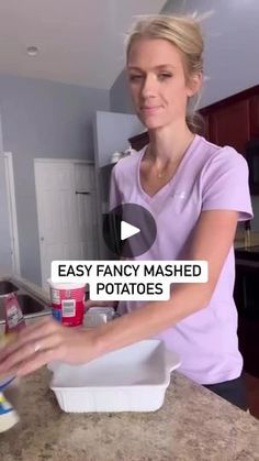 a woman in a purple shirt is making mashed potatoes on a counter top with the words easy fancy mashed potatoes